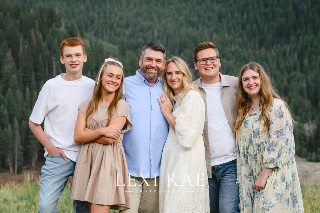 Family in Utah County posing for a photo in the mountains. 