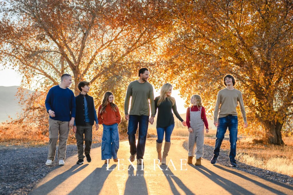 Large family walking on a Utah County fall road holding hands