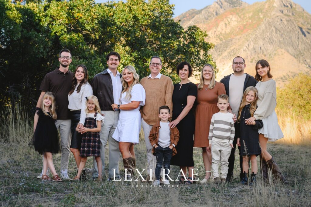 Extended family grouped together in Utah County. Wearing a classic color palette of whites, creams, camel, brown and black. 