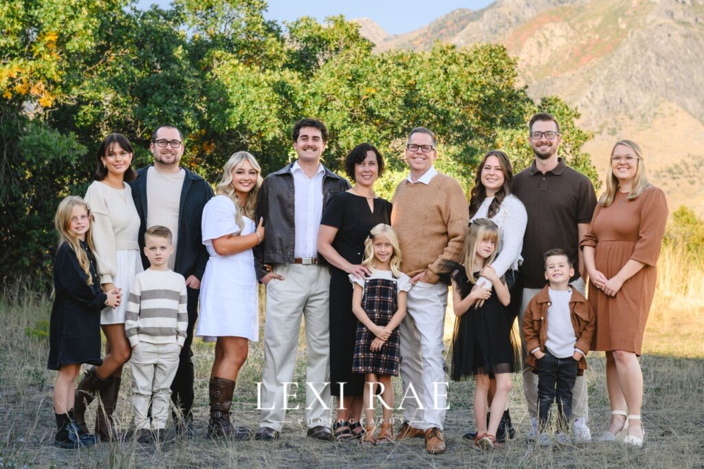 Extended family grouped together in Utah County. Wearing a classic color palette of whites, creams, camel, brown and black. 